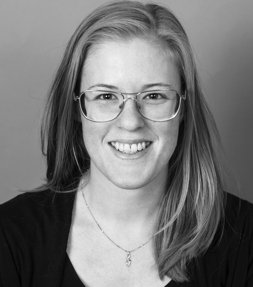 Portrait photo in black and white of company owner Sarah Andersson - woman with glasses and long hair, smiling